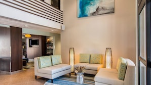 A modern living area with two sofas, a coffee table, and a TV mounted on the wall. - Clarion Inn & Suites Atlanta Downtown (Atlanta)