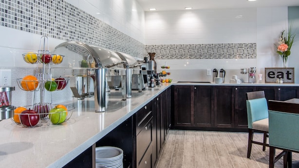 A modern kitchen with a long counter, stainless steel appliances, and a fruit bowl. - Clarion Inn & Suites Atlanta Downtown (Atlanta)