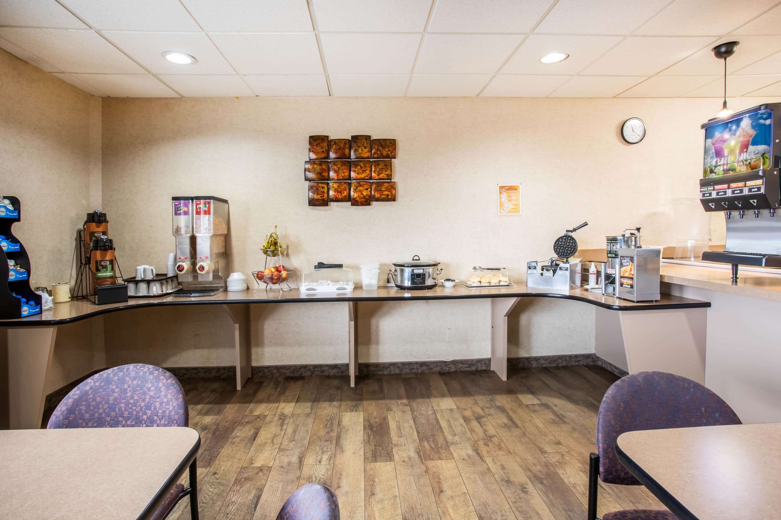 A kitchen area with a long counter, various appliances, and seating.