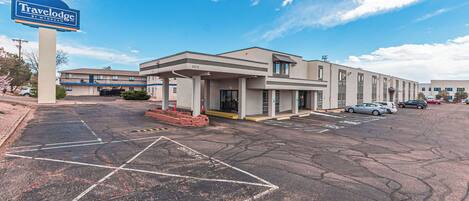 A Travelodge by Wyndham hotel with a parking lot and a building with multiple units.