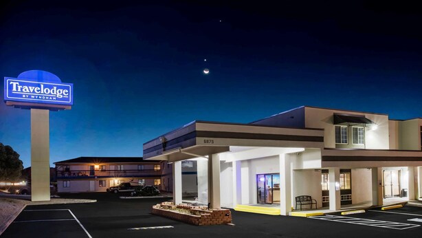 Hotel Travelodge by Wyndham con estacionamiento, un letrero y un edificio de varios pisos con balcón.
