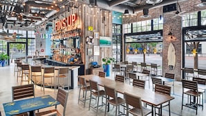 Un restaurante moderno con barra, mesas y sillas de madera.