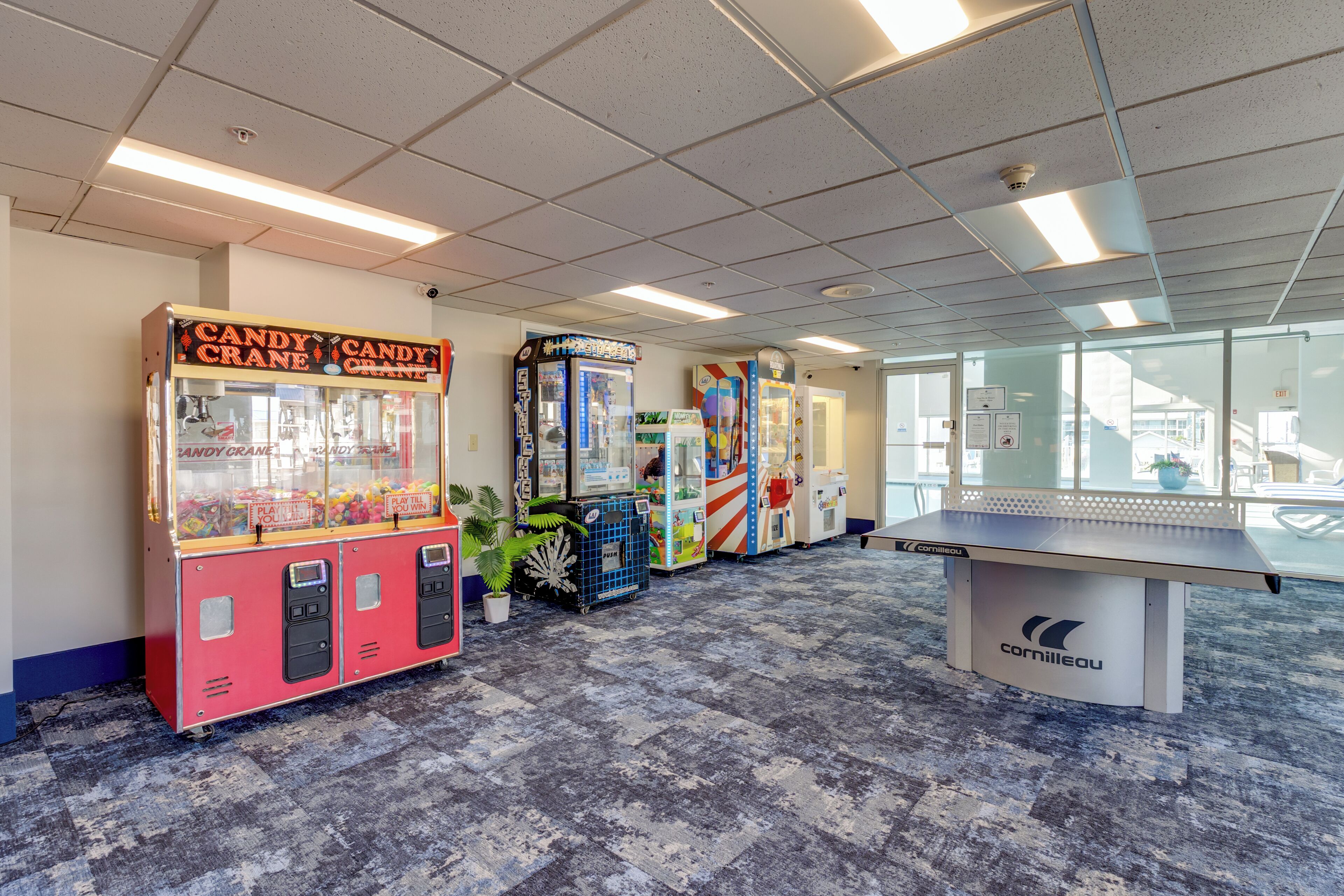 A room with vending machines, a ping pong table, and a view through large windows.