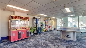 A room with vending machines, a ping pong table, and a view through large windows.