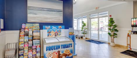 Una librería con una presentación de postres helados, un cuadro grande en la pared y vistas al exterior a través de amplias ventanas.