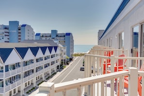 A coastal hotel with multiple balconies, a clear view of the beach, and a street in the foreground.