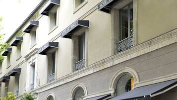 La façade d’un hôtel, ornée de nombreux balcons, un panneau indiquant un restaurant et une enseigne portant l’inscription « Hôtel de l’Image ».