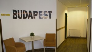 A hallway with a table and two chairs, a radiator, and a wall with the text "BUDAPEST". - Star Hotel by Mellow Mood Hotels (Budapest)