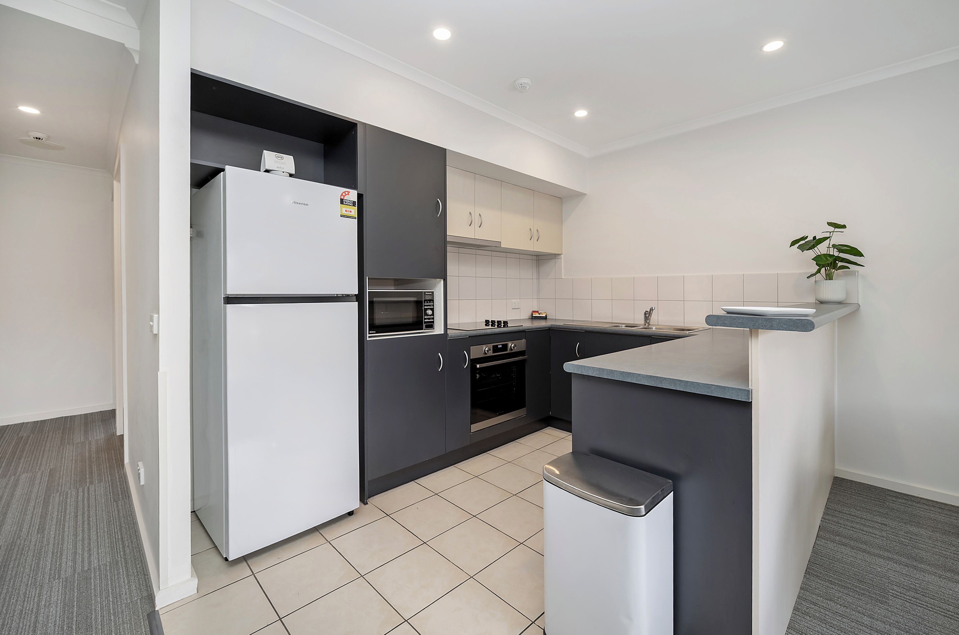 Una cocina moderna con refrigerador, horno, microondas y pileta.