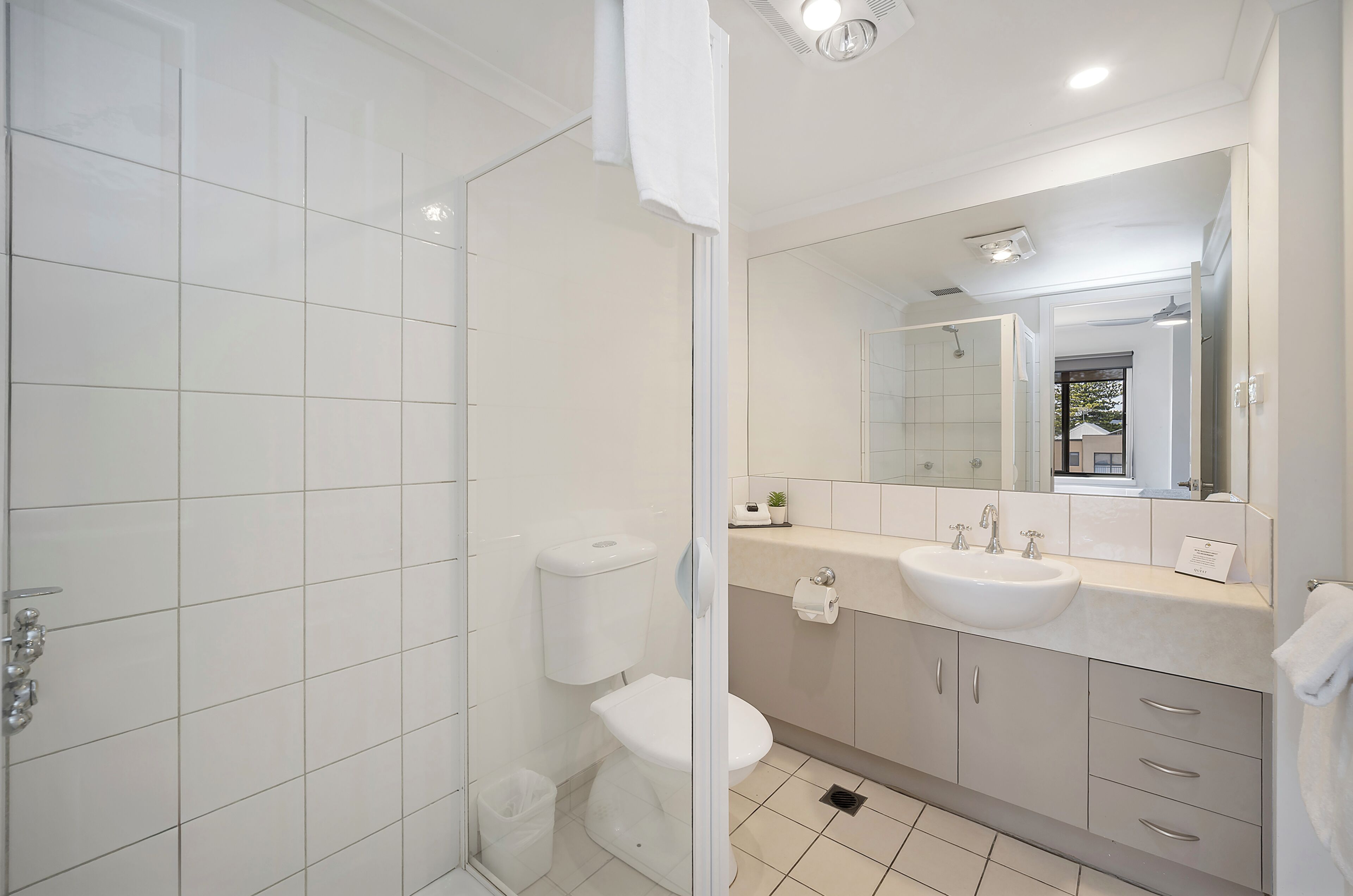 A modern bathroom with a toilet, sink, and shower.