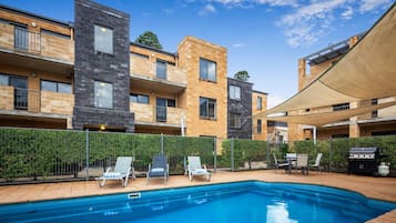 Alberca al aire libre y camastros