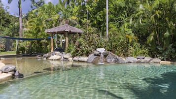 Piscine extérieure, piscine avec cascade, chaises longues