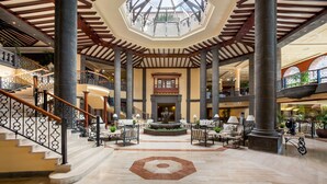 A spacious lobby with a central fountain, high ceilings with wooden beams, and multiple levels accessible by stairs. - Gran Tacande Wellness & Relax Costa Adeje (Adeje)