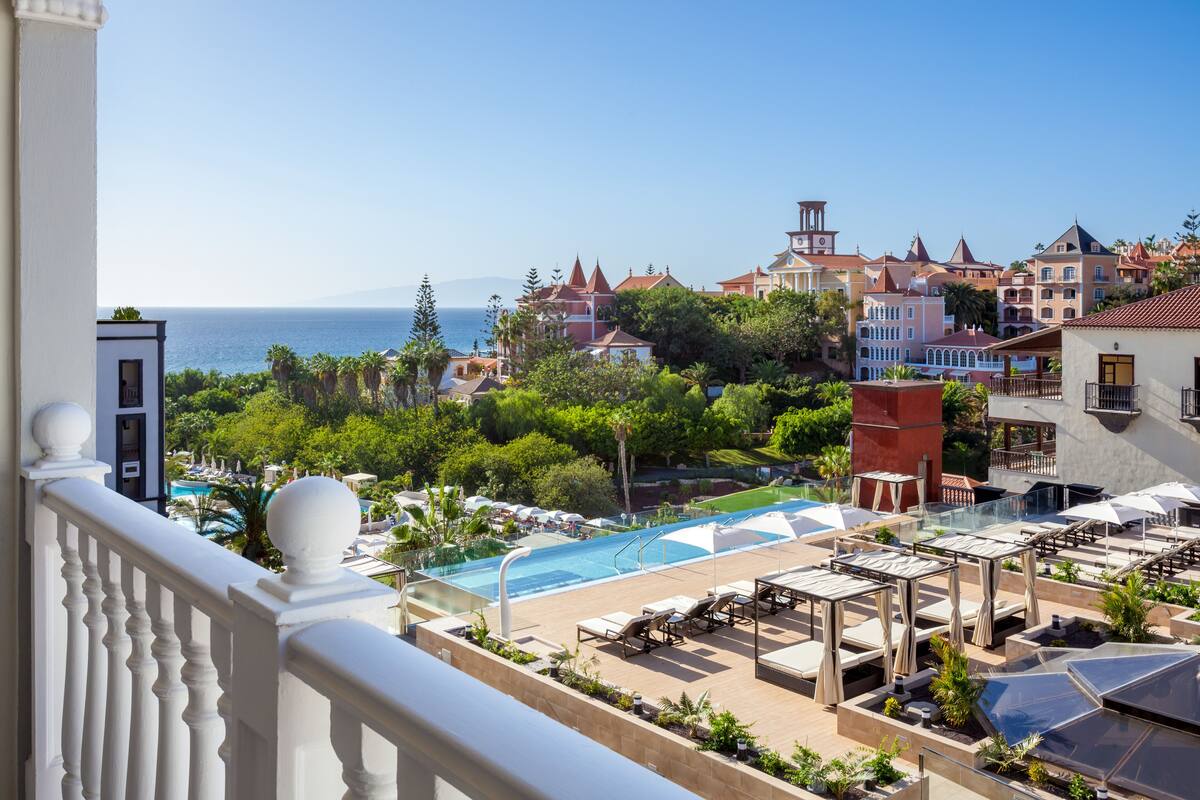 Ein Resort mit Pool, Liegestühlen und Meerblick.