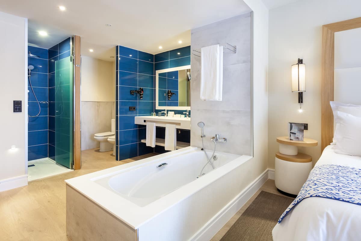 Ein modernes Badezimmer mit einer großen Badewanne, einer Dusche und einem WC.