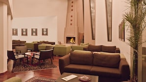 A spacious living area with a fireplace, multiple sofas, and a coffee table. - Kapadokya Lodge (Nevsehir)