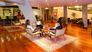 A lobby with a bar area, seating arrangements, and potted plants. - Kapadokya Lodge (Nevsehir)