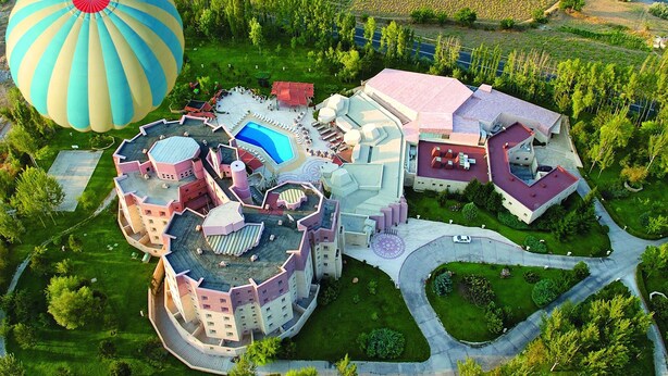 A large, uniquely designed hotel with multiple interconnected buildings, a swimming pool, and a landscaped garden. - Kapadokya Lodge (Nevsehir)