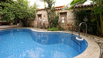 Una piscina al aire libre de temporada, sombrillas