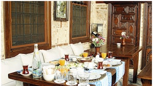 A dining table set with plates, glasses, and a vase of flowers. - Minyon Hotel (Antalya)