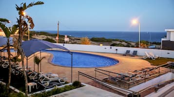 Una piscina cubierta, una piscina al aire libre de temporada, sombrillas