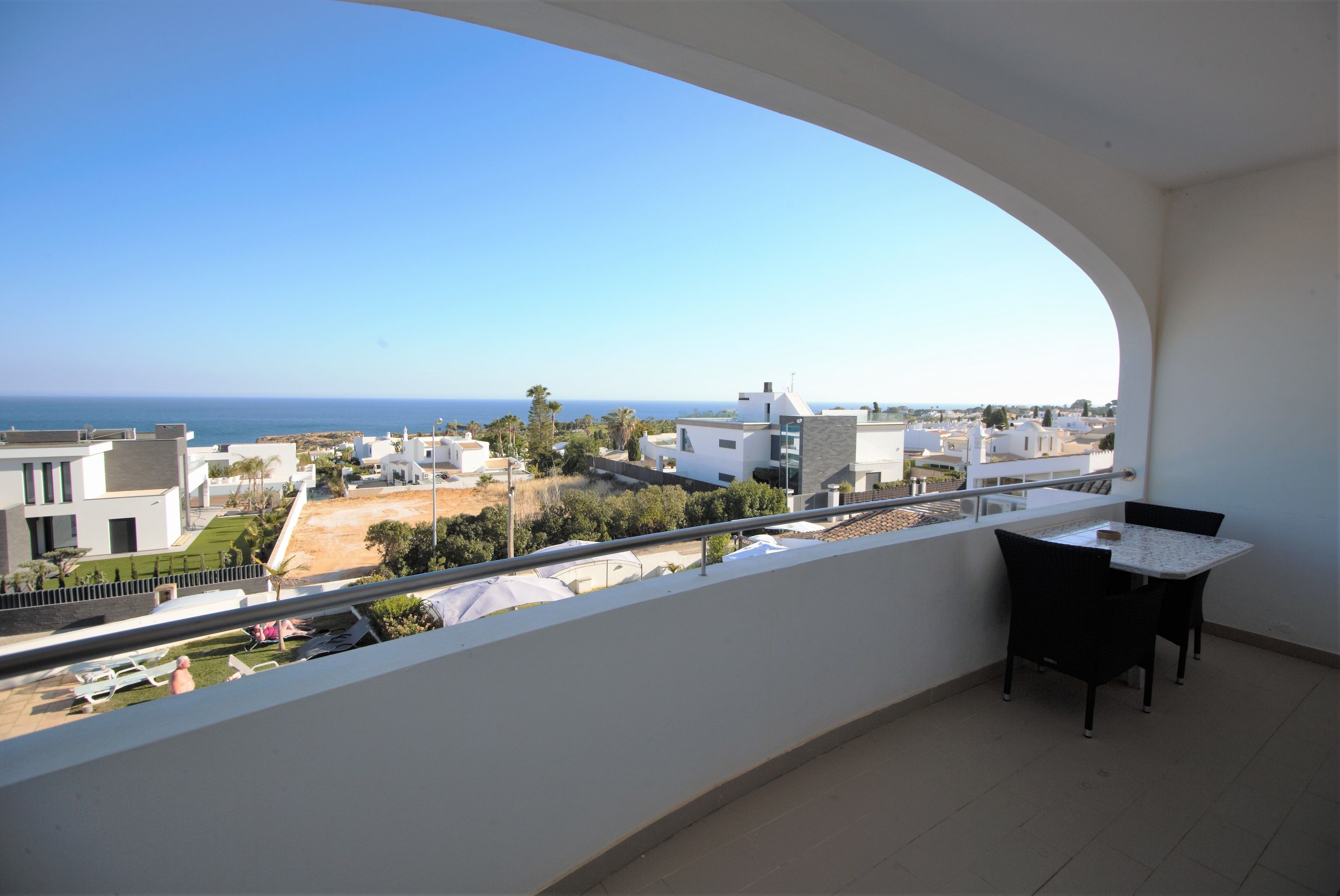 Un balcón con vistas al mar, una mesa y sillas.
