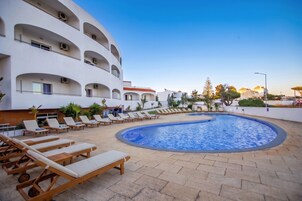Una piscina techada, una piscina al aire libre de temporada, sombrillas