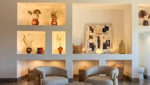 A modern living room with two sofas, a coffee table, and wall-mounted shelves with decorative items. - Hotel Maritur - Adults Only by Pierre & Vacances (Albufeira)