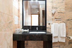 A bathroom with a marble sink, a mirror, and a towel rack. - Hotel Maritur - Adults Only by Pierre & Vacances (Albufeira)