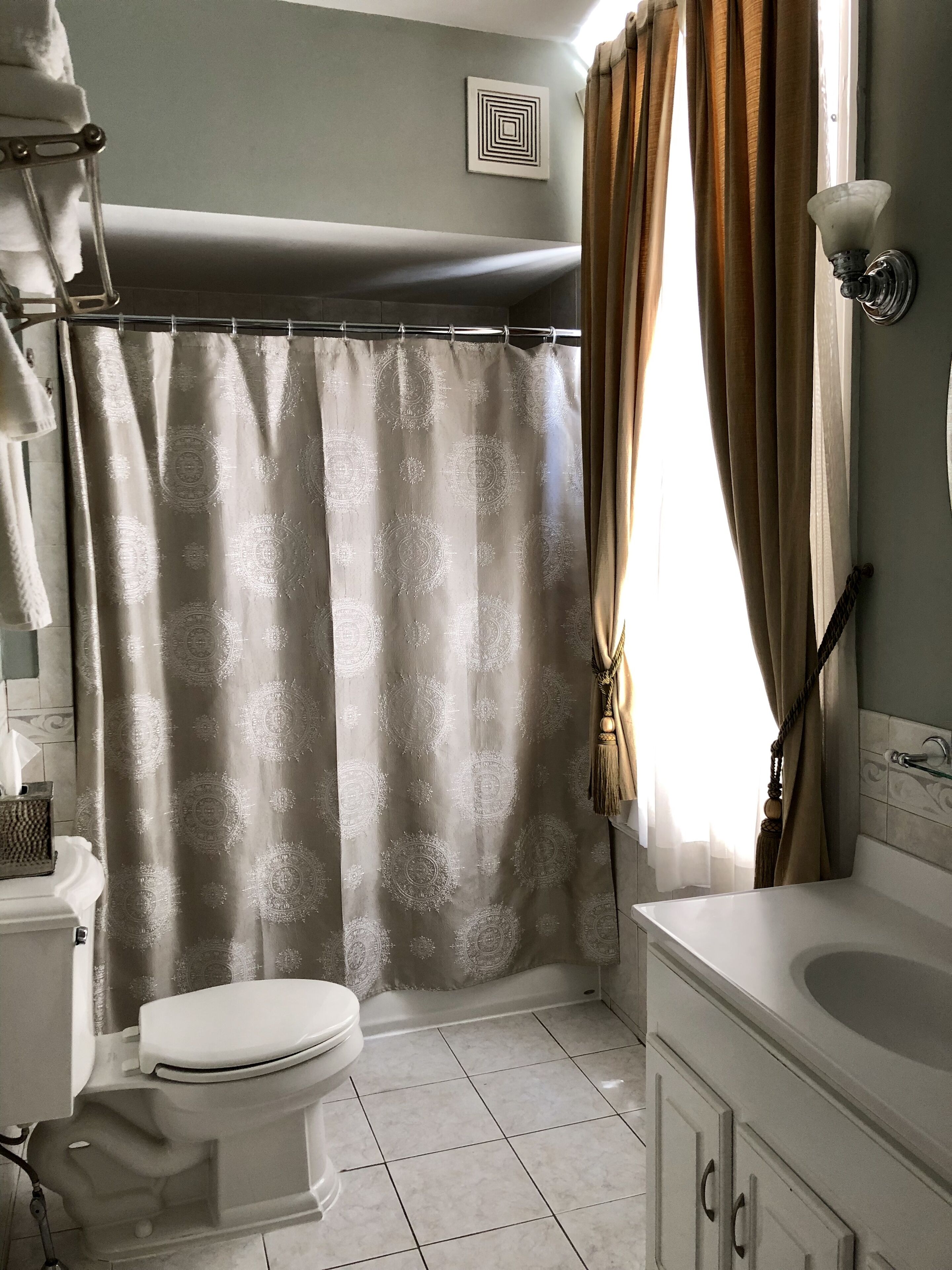 Un bagno con il water, una tenda da doccia e una vasca da bagno.