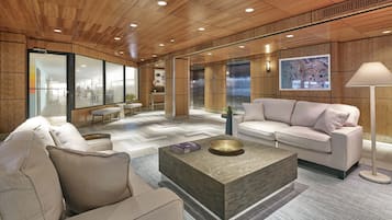 Un interior moderno con techo de madera, un sofá blanco, una mesa de centro y una lámpara.