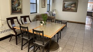 A dining area with a rectangular table, six chairs, and two windows. - Chinatown Hotel Chicago (Chicago)