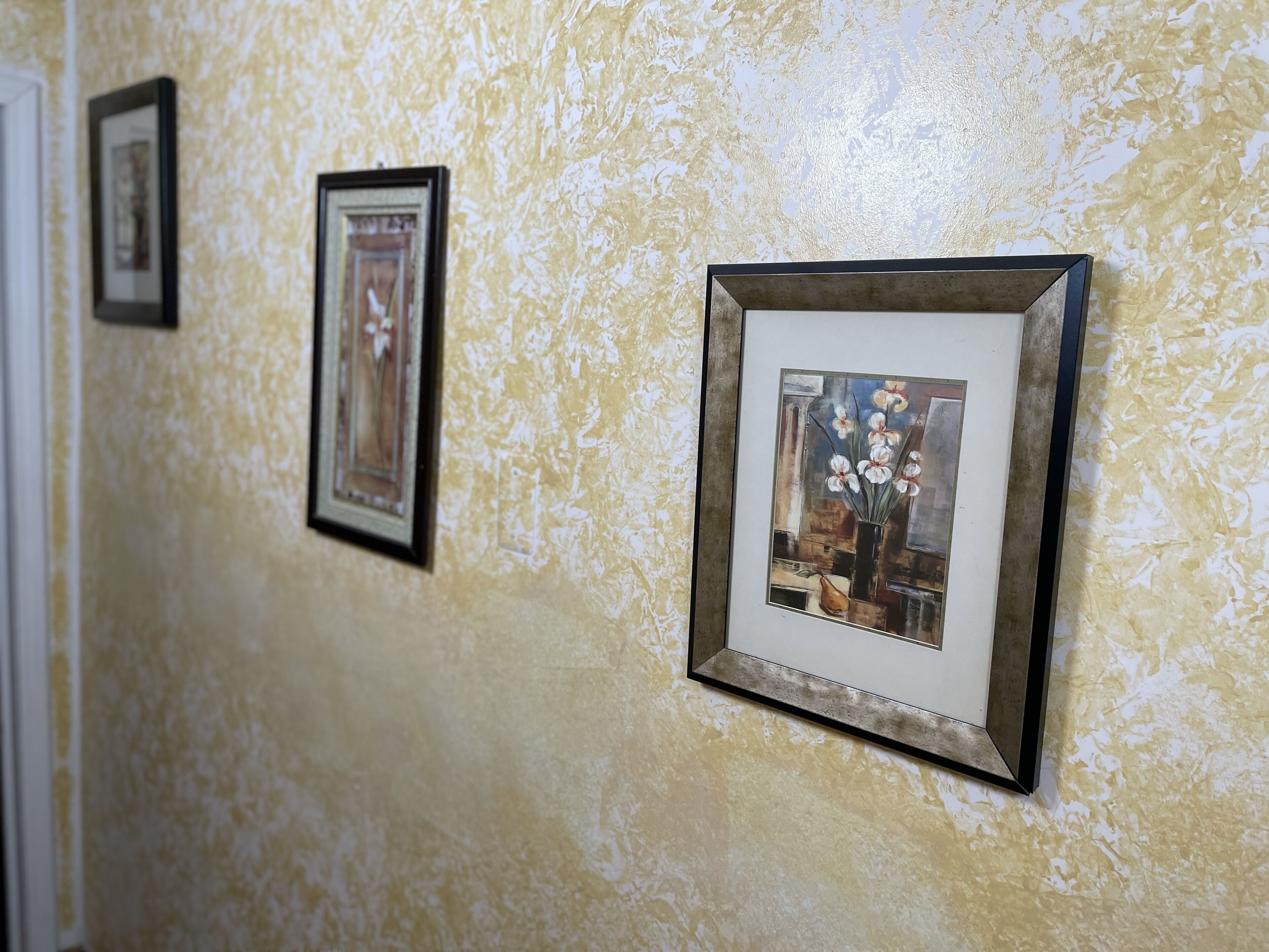 A hallway with framed artwork on the wall.