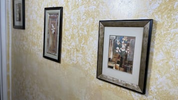 A hallway with framed artwork on the wall.