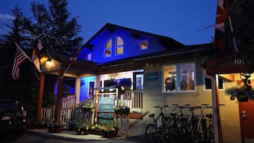 Un edificio con un cartel que dice "Frisco Inn on Galena" y un área de recepción. Hay bicicletas estacionadas afuera y un coche en la calle.
