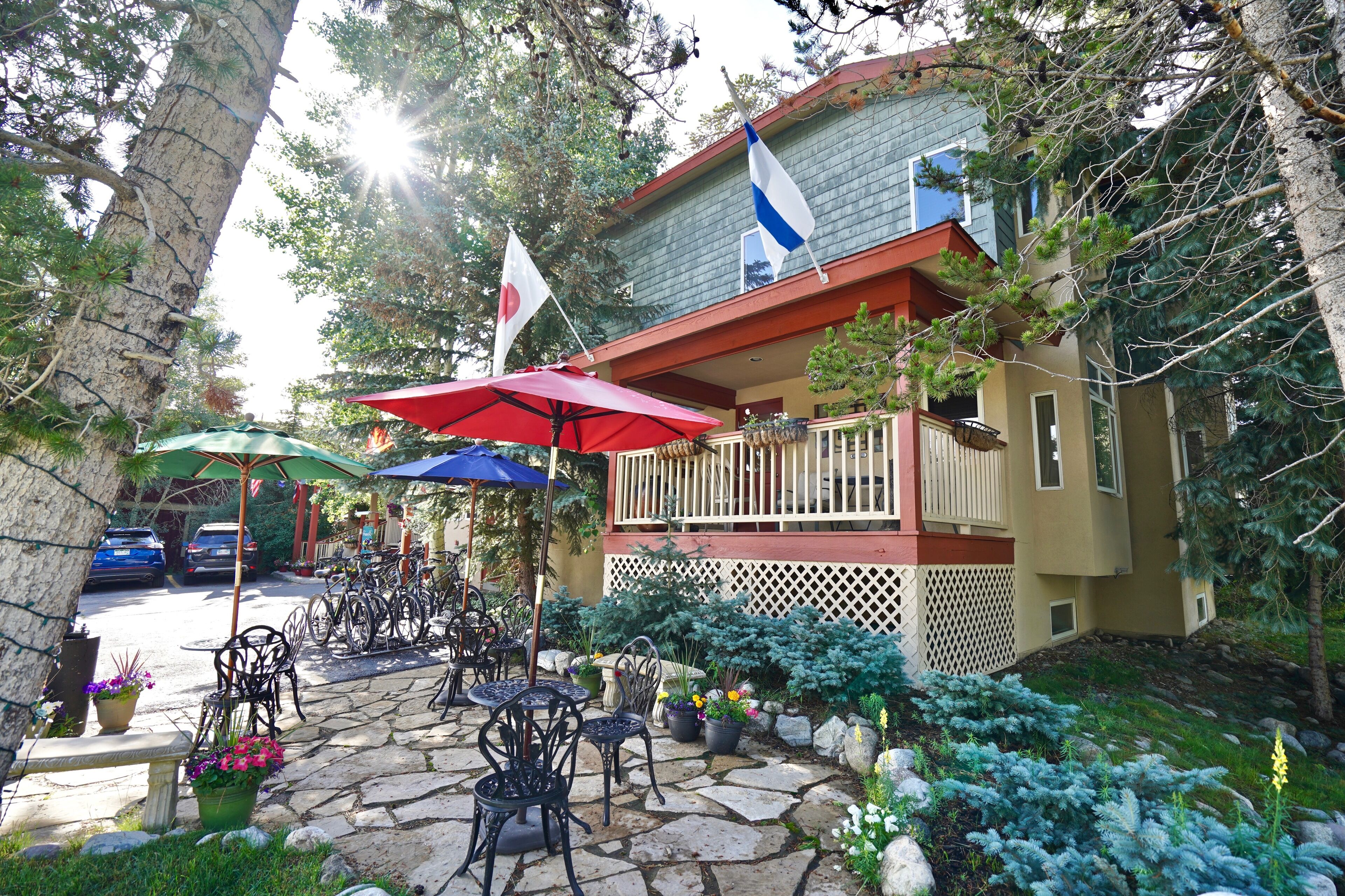 Un espace patio avec des sièges d’extérieur, un chemin en pierre et un bâtiment doté d’un balcon.