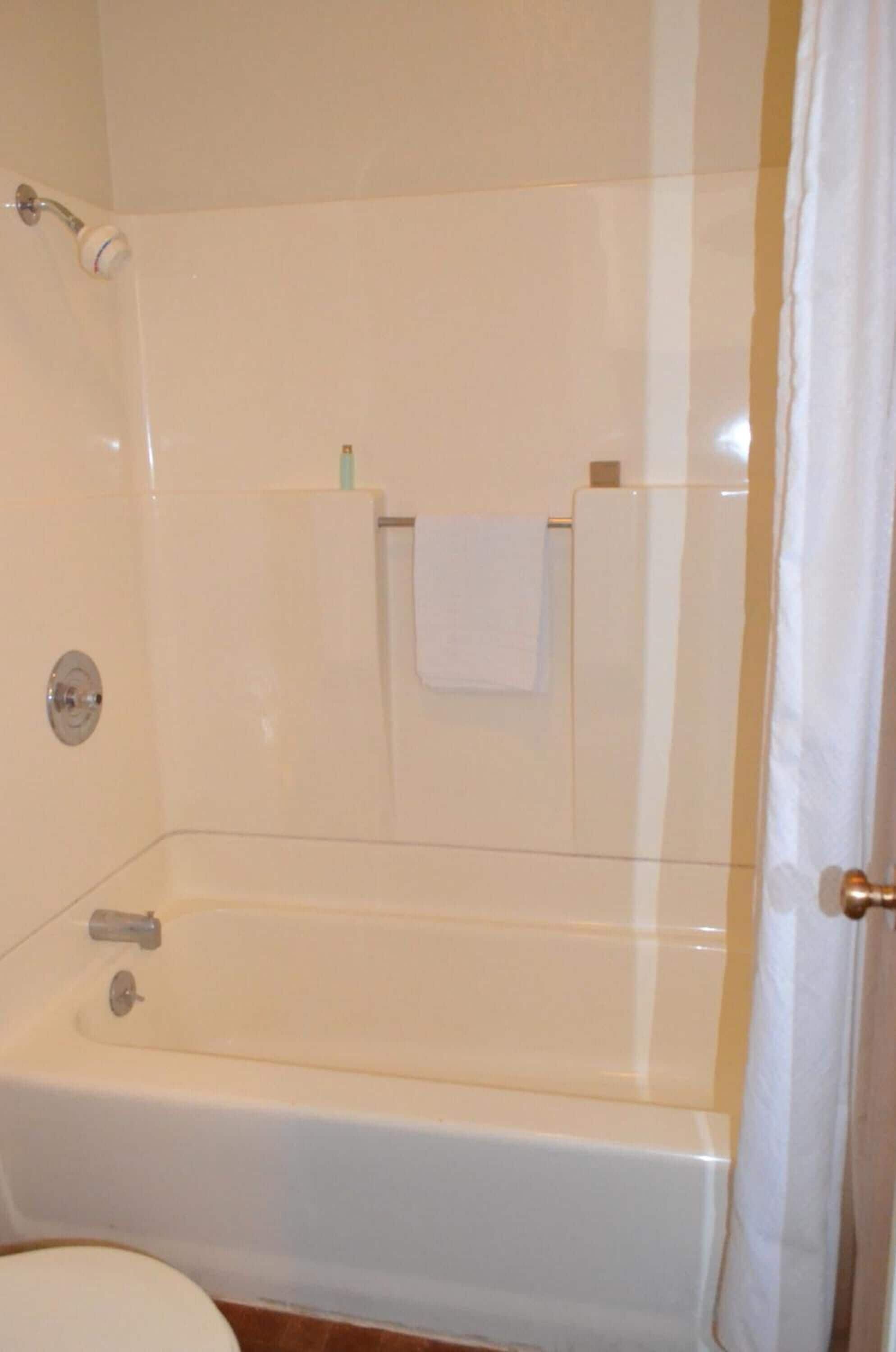 A bathroom with a bathtub, toilet, and shower.