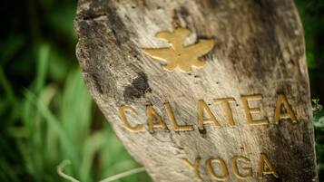 A wooden sign with the text "CALATEA YOGA" and a leaf design.