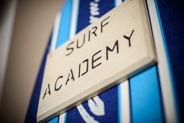 A wooden sign with "SURF ACADEMY" written on it.