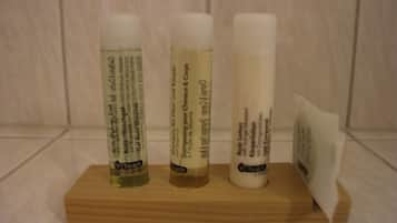 Three bottles of Touch body care products on a wooden tray.