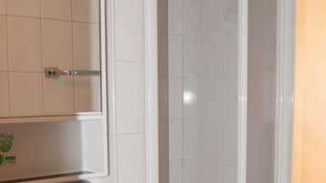 A bathroom with a shower, sink, and toilet.