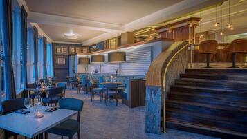 A restaurant with a bar area, a staircase, and a seating arrangement.