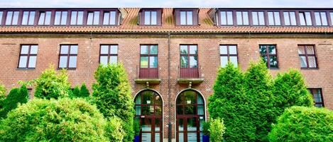 A brick building with arched double doors, a flat roof, and a brick facade.