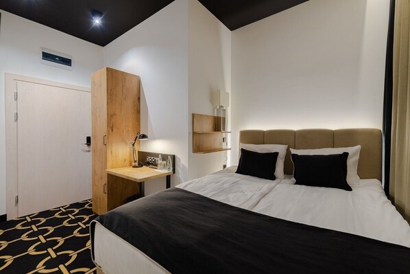 A hotel room with a bed, a wooden wardrobe, a desk, and a bedside table. - Jess Hotel Krolewski Gdansk Old Town (Gdansk)