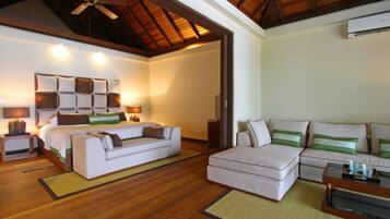 Una habitación luminosa con una cama, dos sofás, una mesa de centro y un ventilador de techo.