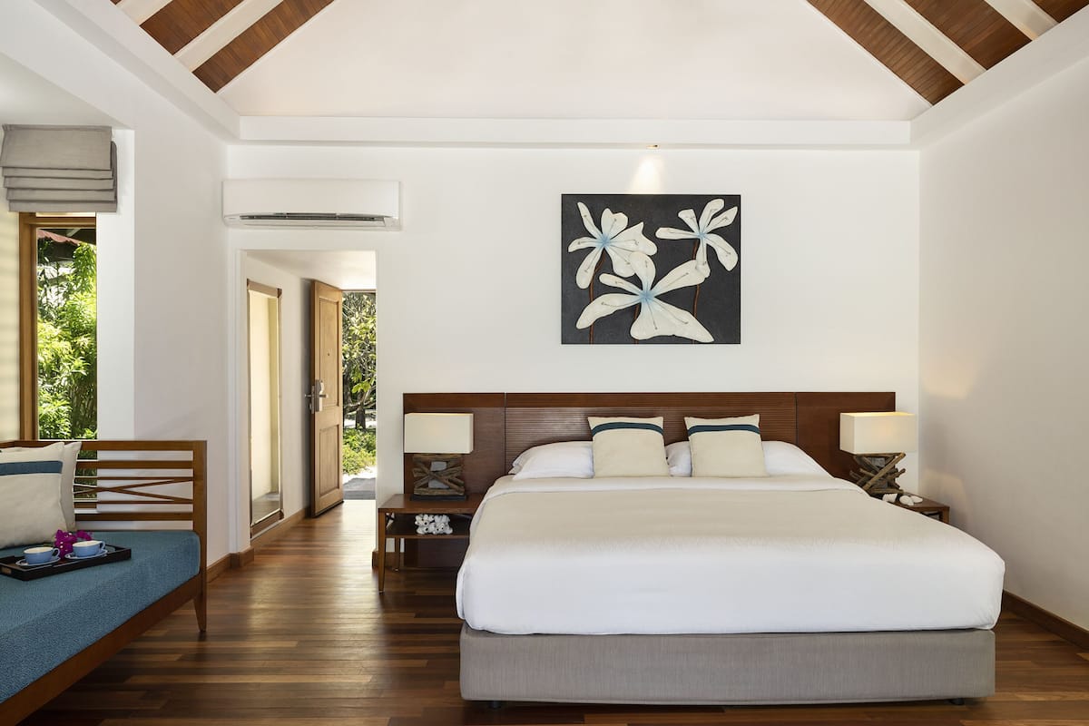 Camera d'albergo con un letto grande, comodini, un'opera d'arte appesa al muro e vista sull'esterno.