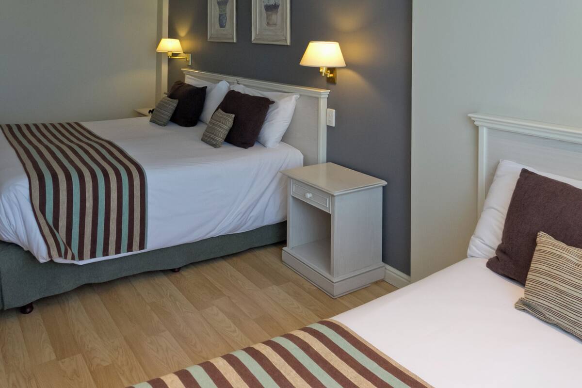 Ein Hotelzimmer mit Bett, Nachttisch und Beistelltisch.