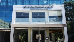 Um hotel moderno com fachada de vidro e uma placa com a inscrição 'AMERICAN CATAMARCA PARK HOTEL'.