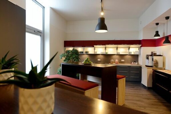 Une cuisine moderne dotée d’un îlot central, de luminaires suspendus et offrant une vue sur la salle à manger adjacente.