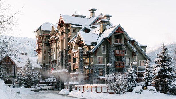 Un hotel de varios pisos con un estilo arquitectónico tradicional, que presenta balcones y fachada de piedra.